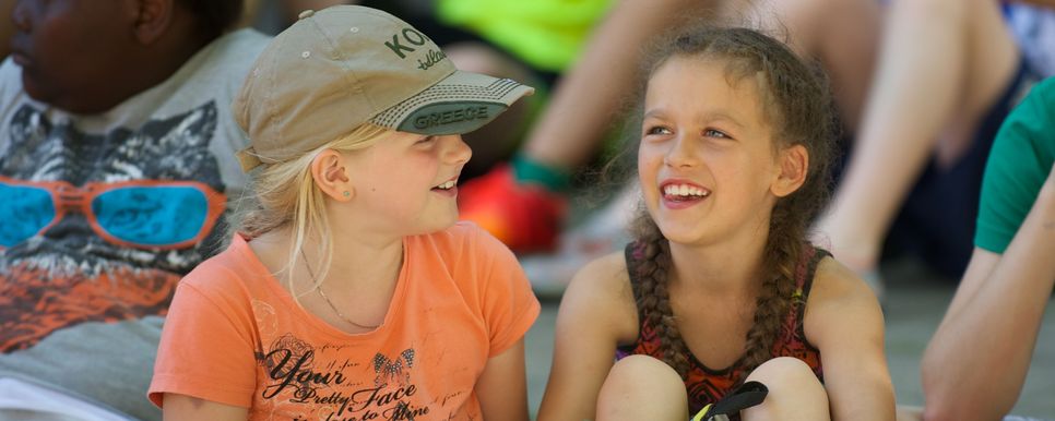 Jungscharkinder beim Kaleidio (Foto: Babsi Maly) Zwei Mädchen bei einer Jungschargroßveranstaltung unterhalten sich.