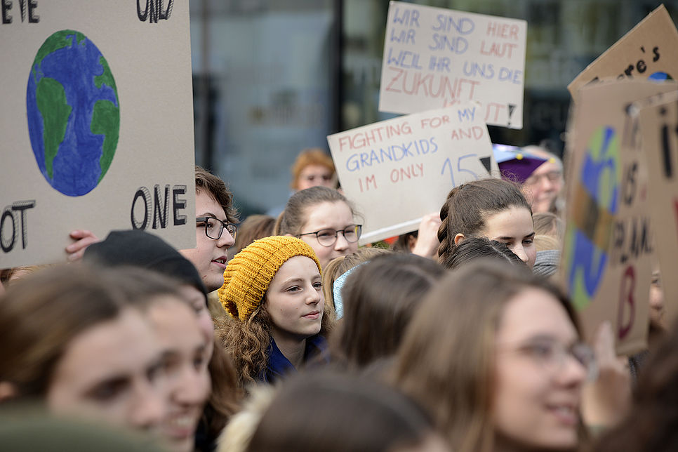 Jugendliche protestieren mit Plakaten für mehr Klimaschutz.