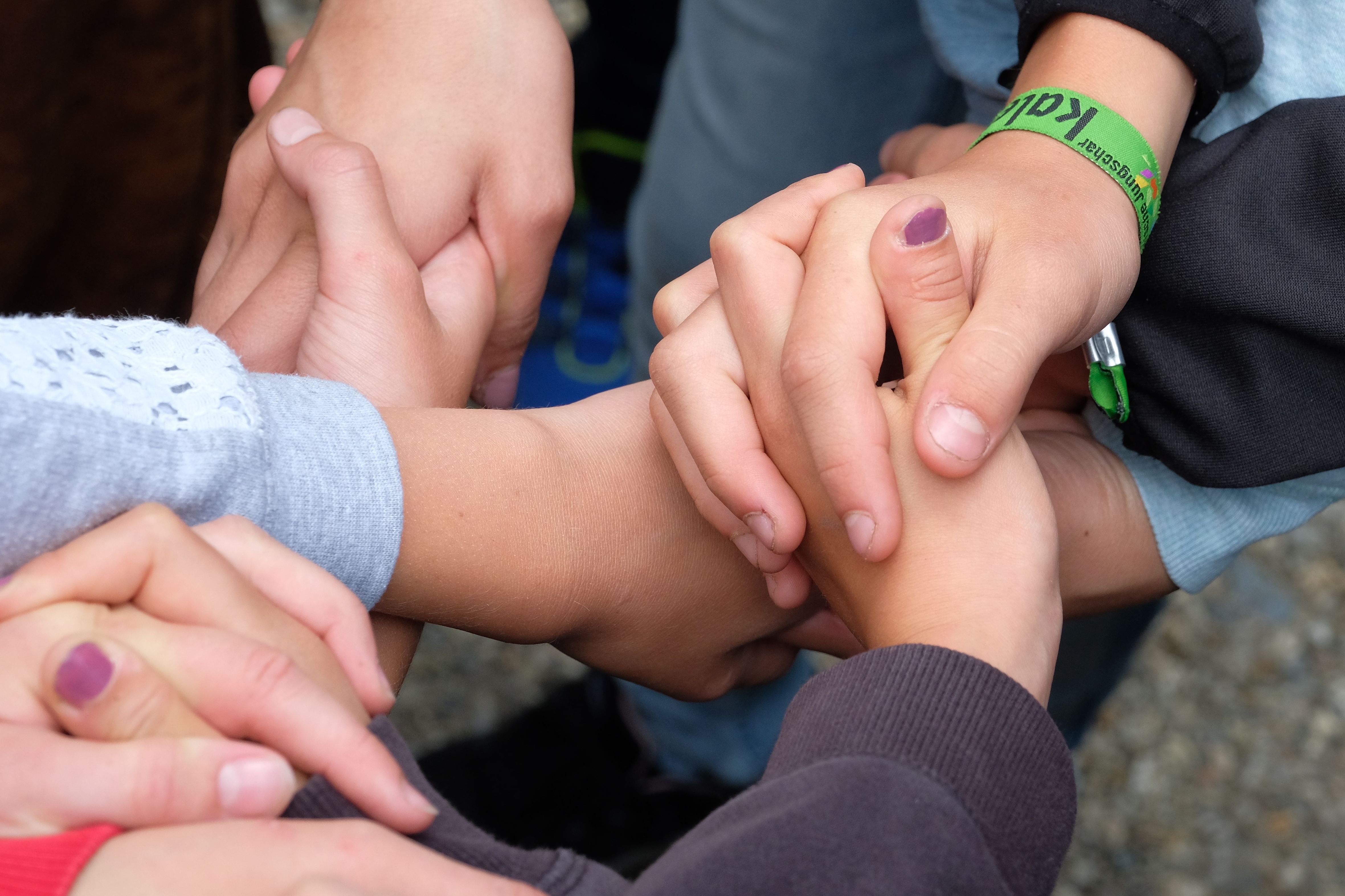 Kinderhände halten sich gegenseitig fest.